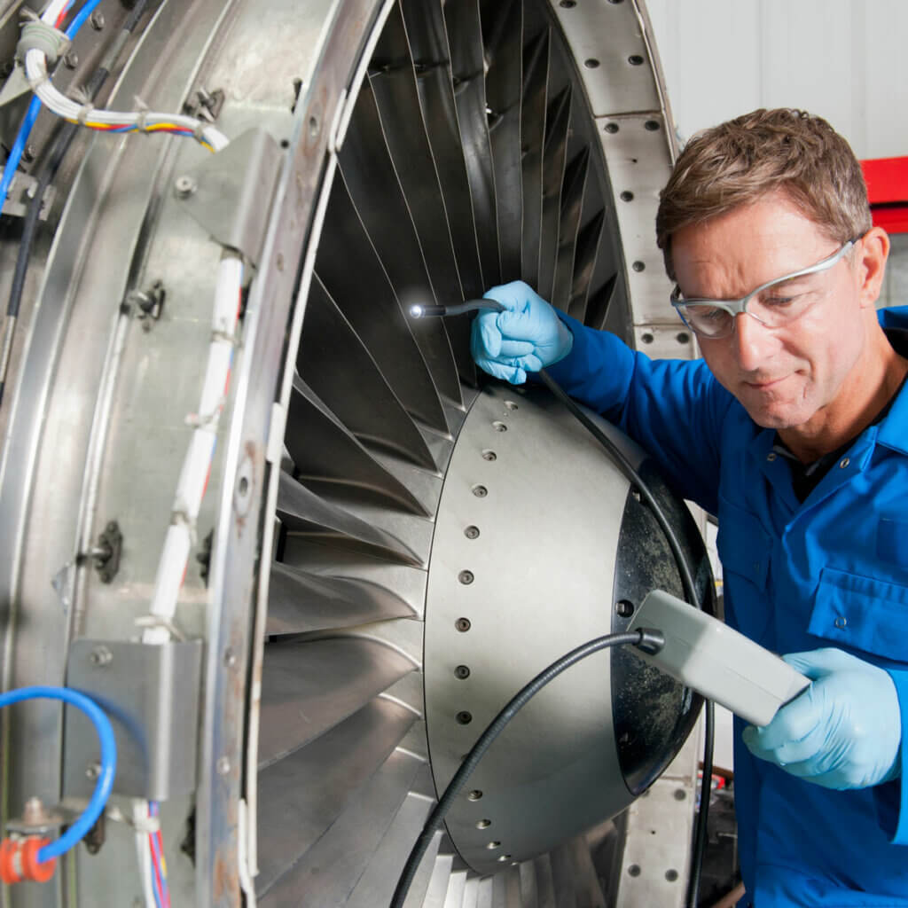 engineer-inspecting-the-turbine-engine-of-a-passenger-jet-at-a-hangar